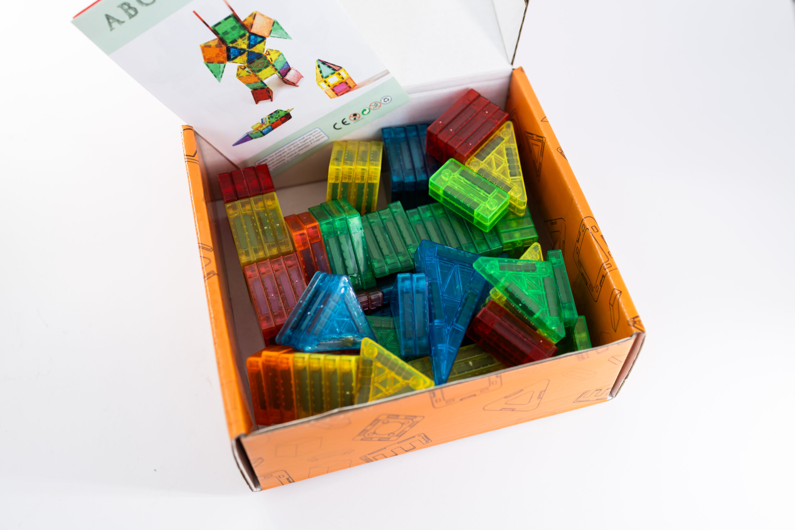 Geopende doos met magnetische bouwblokken in verschillende kleuren en vormen